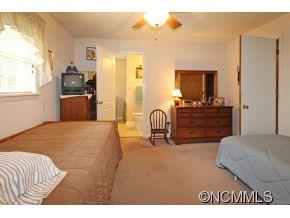265 Hideaway Creek Road Clyde, NC 28721 - Photo 16 of 20 a bedroom with a bed and dresser with mirror