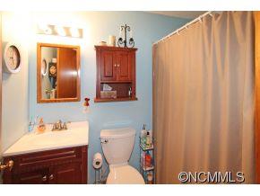 265 Hideaway Creek Road Clyde, NC 28721 - Photo 19 of 20 a bathroom with a sink a mirror and a toilet