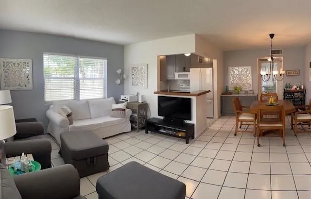 a living room with furniture a fireplace and a chandelier