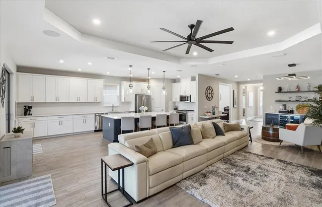 a large kitchen with stainless steel appliances kitchen island granite countertop a table chairs sink and cabinets