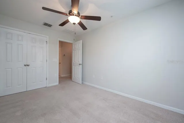 an empty room with a ceiling fan and a window