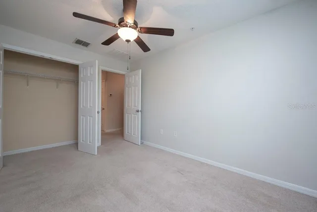 an empty room with a ceiling fan and a fan