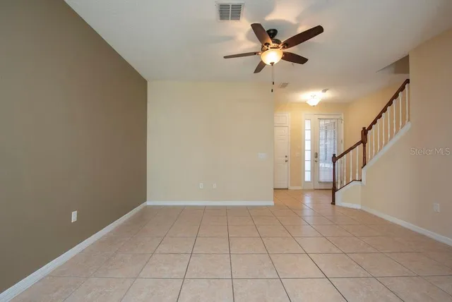 a view of an empty room and a ceiling fan