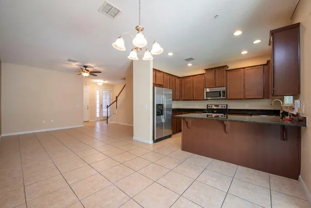 a kitchen with kitchen island granite countertop stainless steel appliances cabinets a sink and a counter top