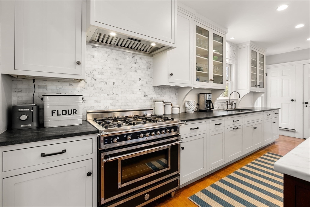 9 Maple Road Weston, MA 02493 - Photo 12 of 35 a kitchen with white cabinets stainless steel appliances and wooden floor