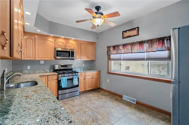 a kitchen with stainless steel appliances granite countertop a stove and a sink
