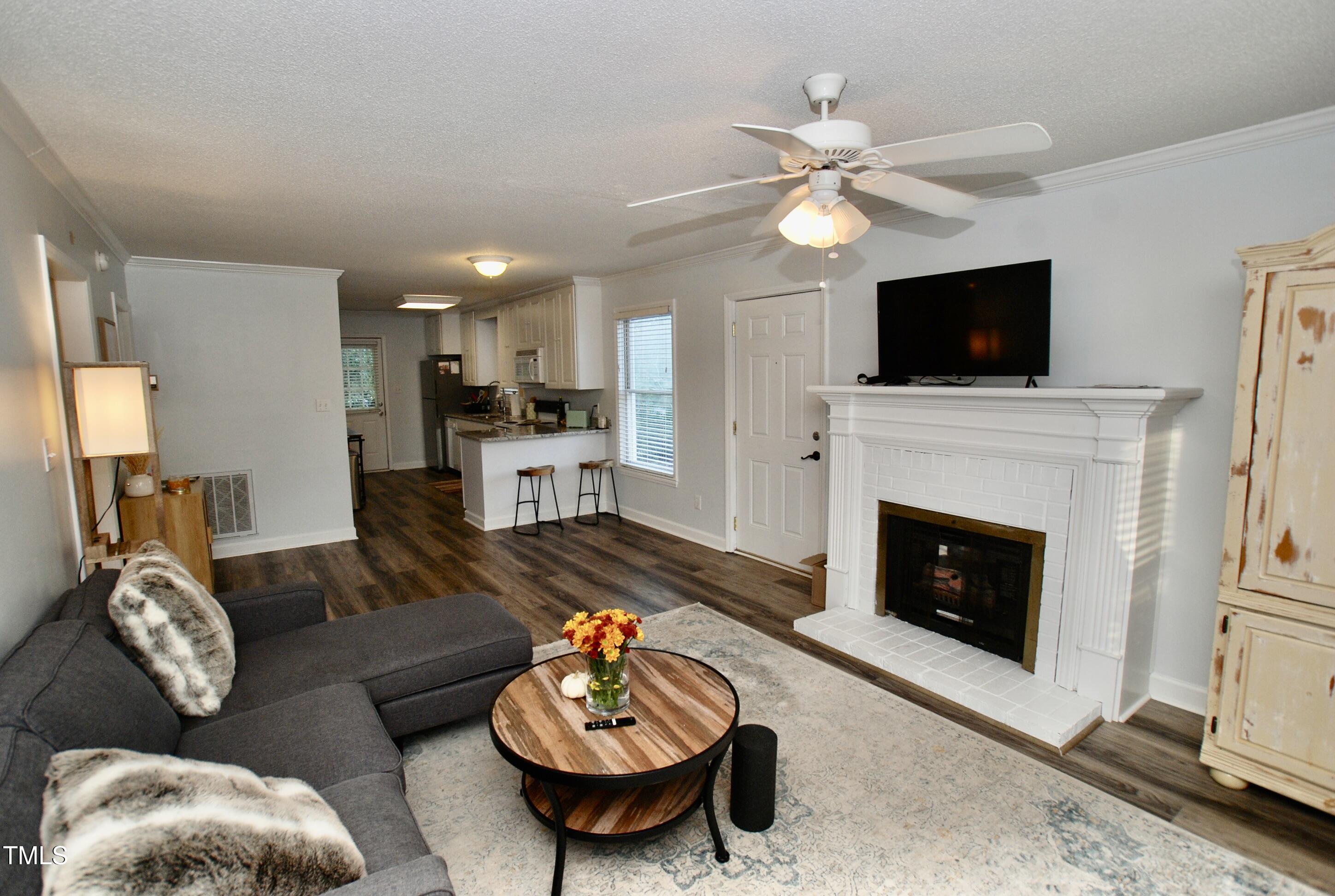 2306 Stafford Avenue, Unit B Raleigh, NC 27607 - Photo 3 of 29 a living room with furniture a flat screen tv and a fireplace