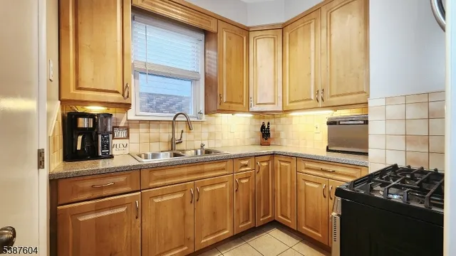 a kitchen with stainless steel appliances granite countertop a sink stove and cabinets