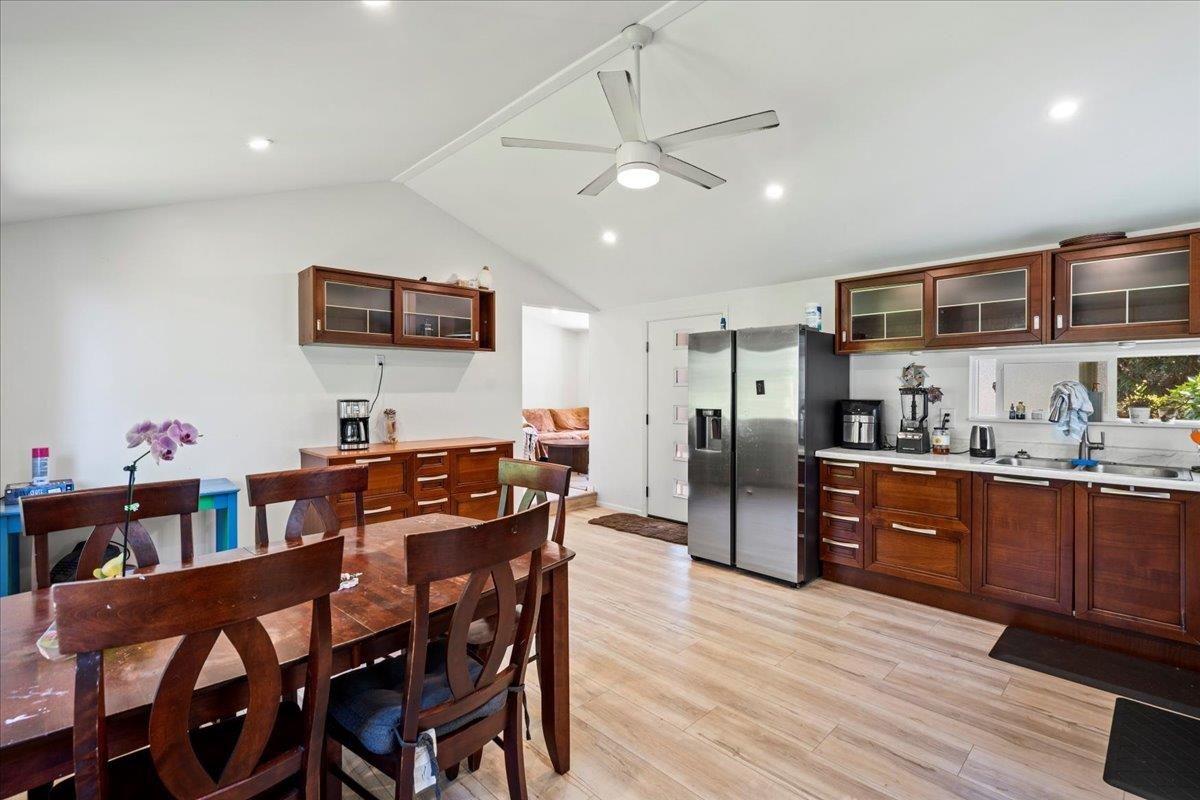 265 Hahana Road Haiku, HI 96708 - Photo 7 of 48 a kitchen with stainless steel appliances kitchen island granite countertop a refrigerator a stove a microwave oven a dining table and chairs with wooden floor