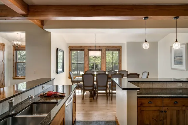 a kitchen with a stove a sink and dishwasher with a dining table