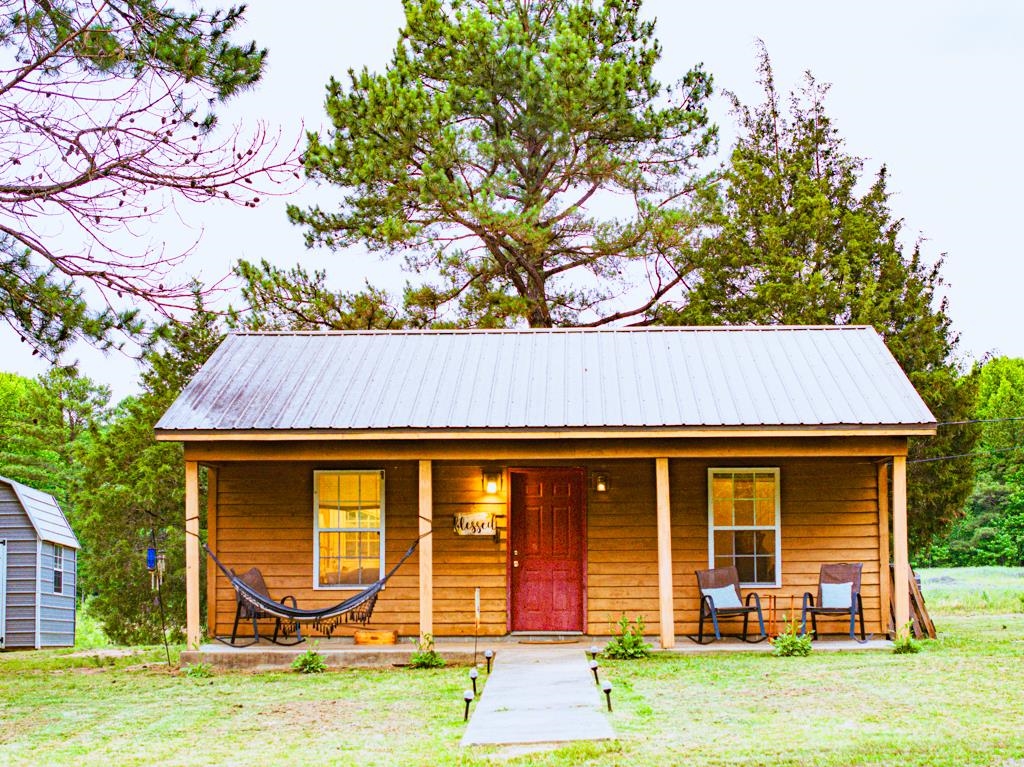 0 Poplar Grove Cemetery Road Henning, TN 38041 - Photo 4 of 40 Wood-sided structure featuring a metal roof and an inviting front porch