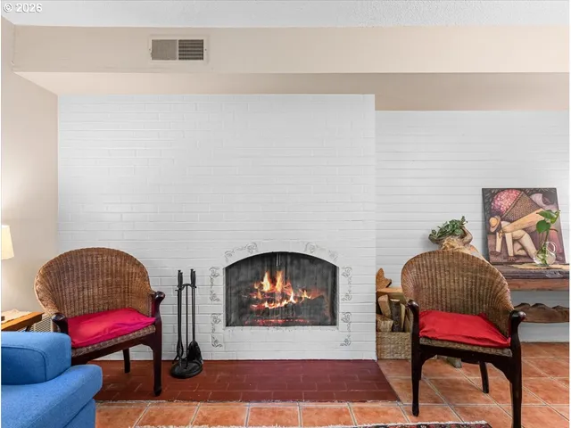 a living room with furniture a fireplace and a chandelier