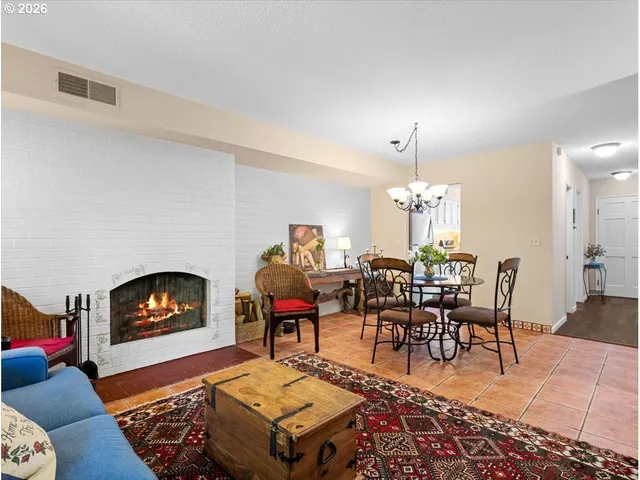 a living room with furniture a dining table and a chandelier