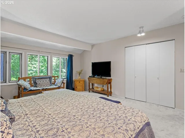 a bedroom with a bed and a flat screen tv