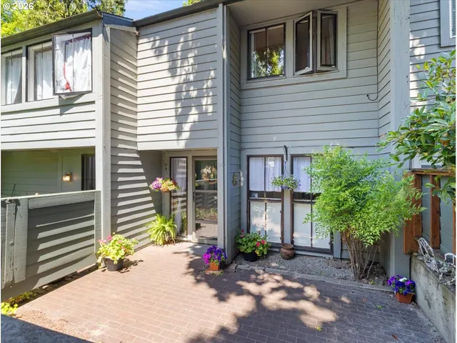 a view of a house with potted plants and a trees