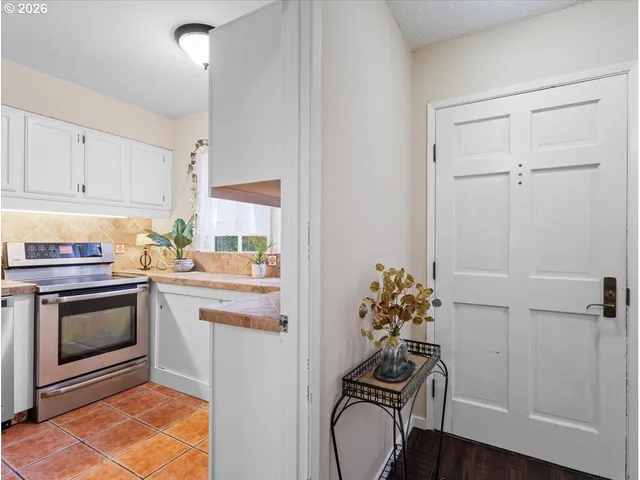 a kitchen with granite countertop white cabinets and white appliances
