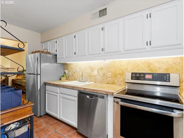 a kitchen with a refrigerator and a sink