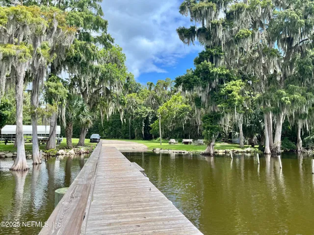 a view of water pond with green yard