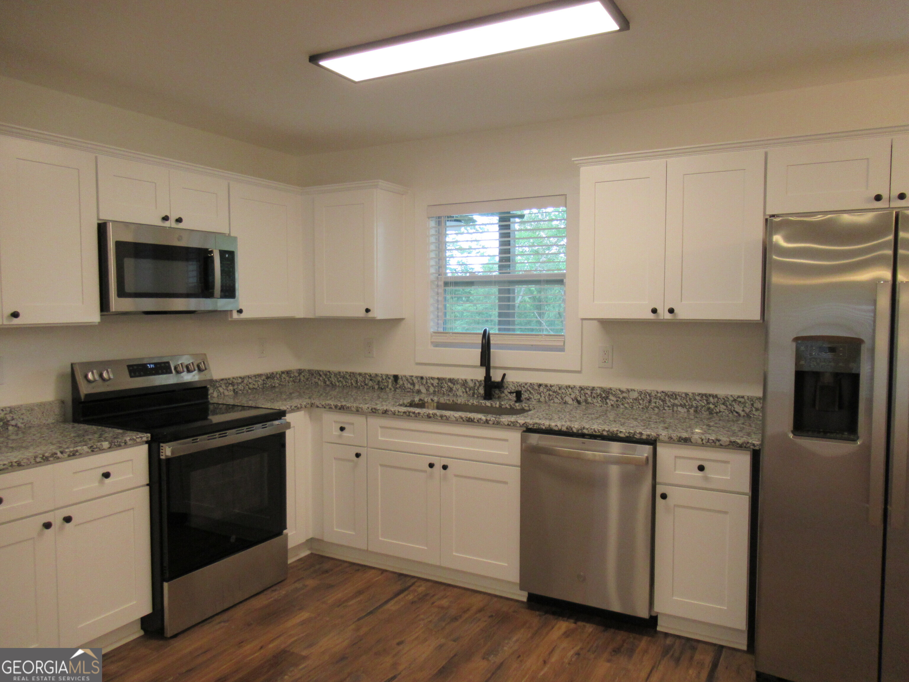 765 Old Kerns Road Dawsonville, GA 30534 - Photo 8 of 36 a kitchen with appliances a sink and cabinets