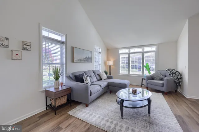 a living room with furniture and hard wood floor
