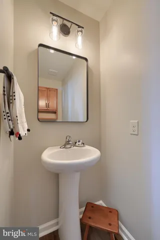 a kitchen with a stove a sink dishwasher a dining table and chairs with wooden floor