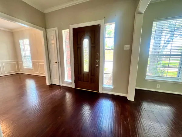 an empty room with wooden floor and windows