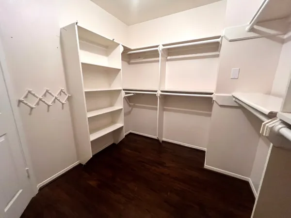 a view of walk in closet with empty racks