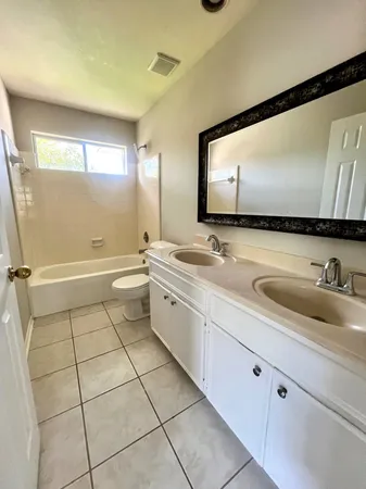 a bathroom with a double vanity sink mirror and toilet