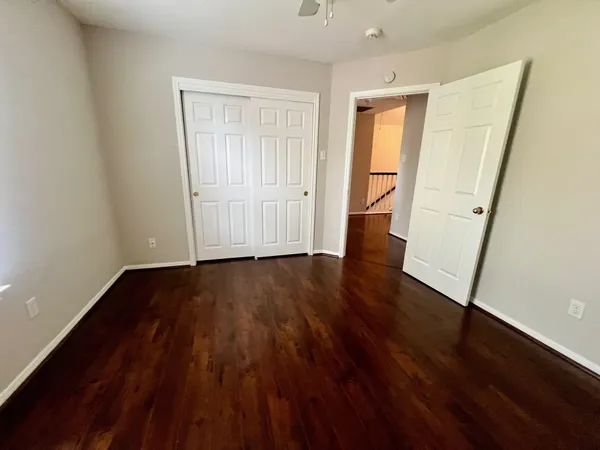 an empty room with wooden floor and closet