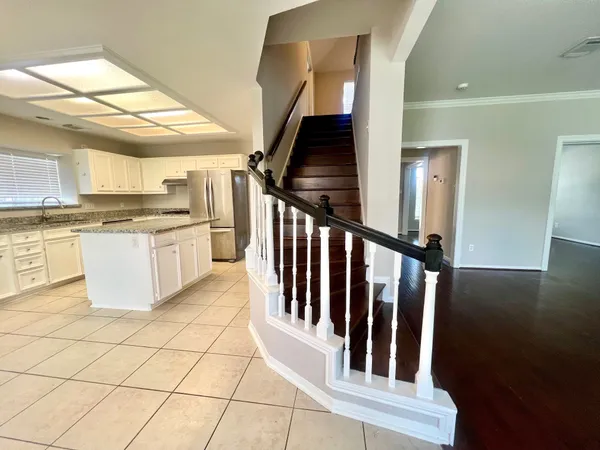 a kitchen with granite countertop a stove a sink and a refrigerator