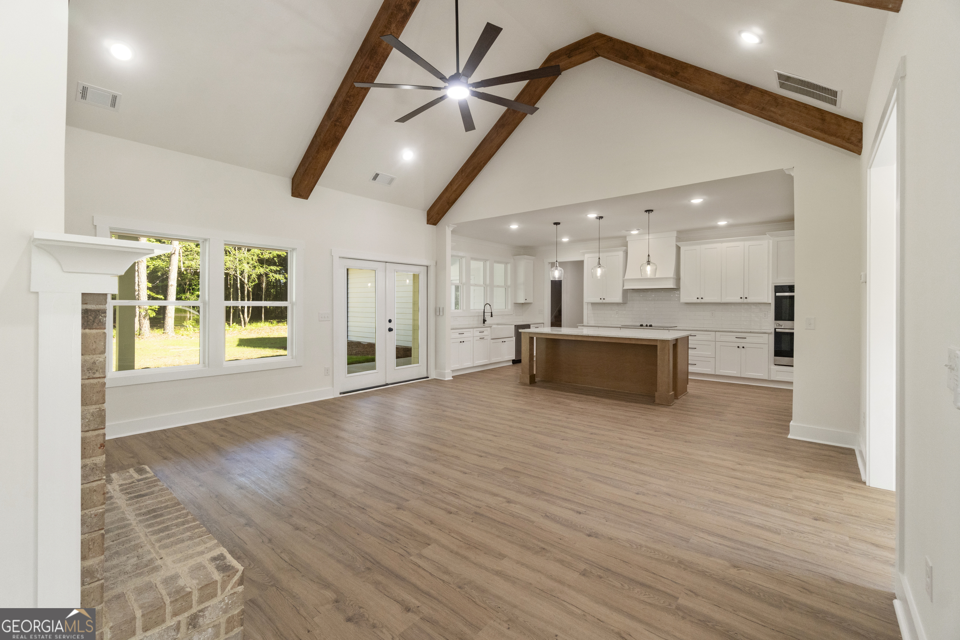 1251 Simmons Road Social Circle, GA 30025 - Photo 3 of 7 a view of a big room with wooden floor and a kitchen