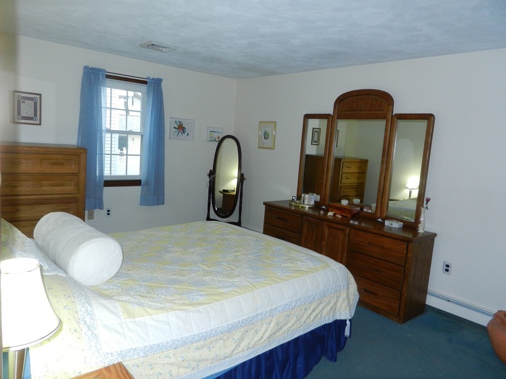32 Intervale Road Waltham, MA 02453 - Photo 9 of 14 a bedroom with a bed a mirror on dresser and a large mirror