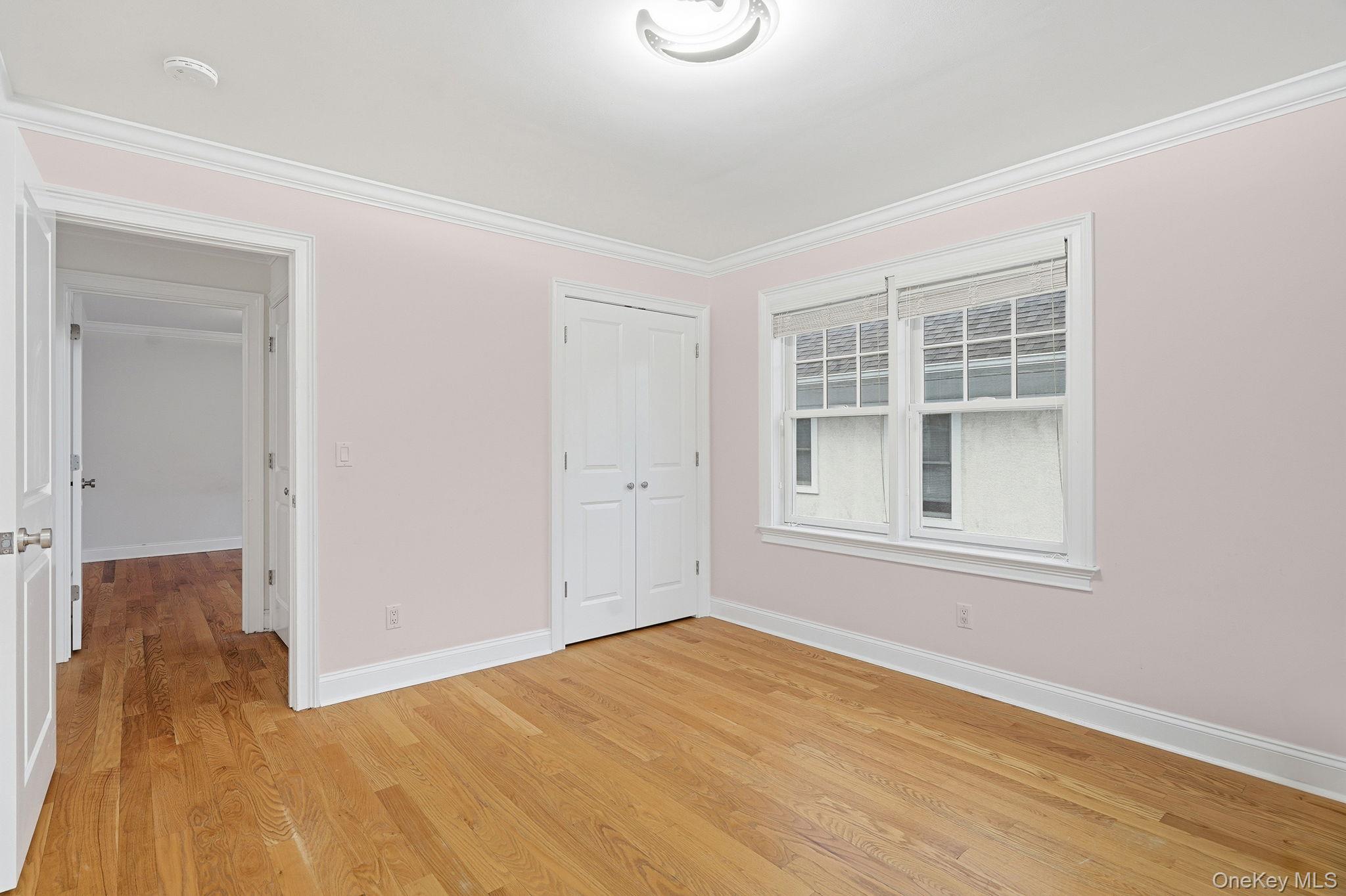 228 Central Avenue Rye, NY 10580 - Photo 19 of 24 a view of an empty room with wooden floor and a window
