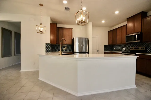 a kitchen with granite countertop a refrigerator and a stove