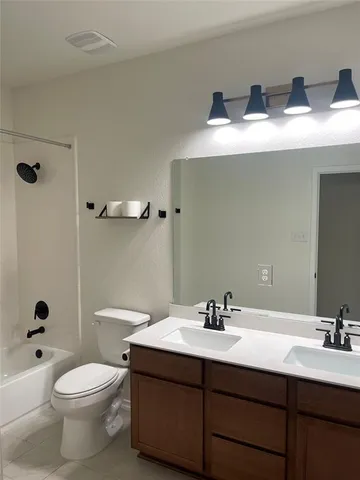 a bathroom with a double vanity sink toilet mirror and shower