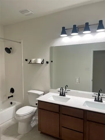 a bathroom with a double vanity sink toilet mirror and shower
