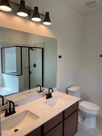 a bathroom with a granite countertop sink toilet and mirror