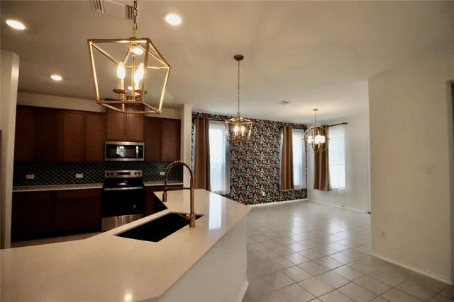 a kitchen with granite countertop a stove and a refrigerator