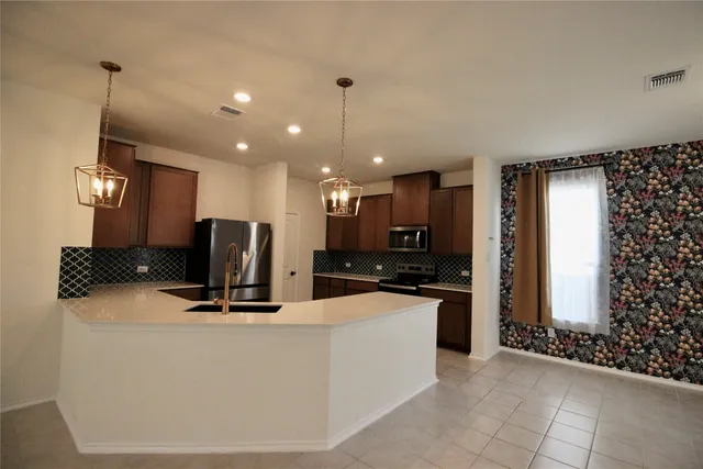 a kitchen with kitchen island sink and refrigerator