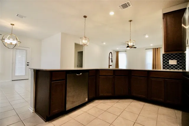 a kitchen with stainless steel appliances kitchen island granite countertop a refrigerator and a sink