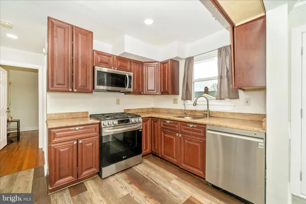 a kitchen with stainless steel appliances granite countertop a stove top oven a sink dishwasher and microwave oven