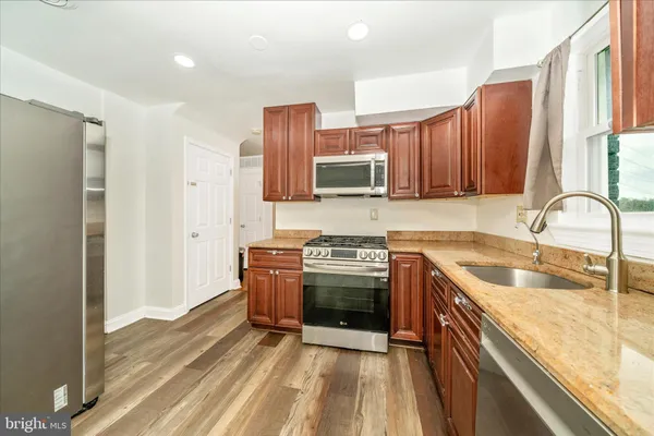 a kitchen with stainless steel appliances granite countertop a sink stove and refrigerator