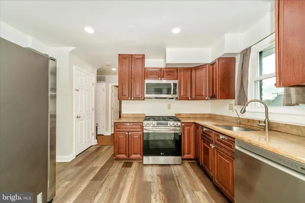 a kitchen with stainless steel appliances granite countertop a sink stove and refrigerator