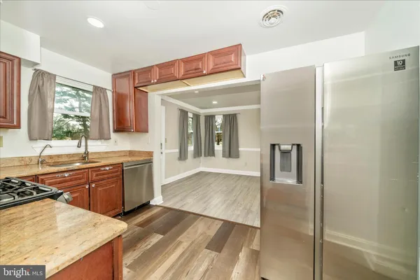 a kitchen with stainless steel appliances granite countertop a refrigerator and a sink