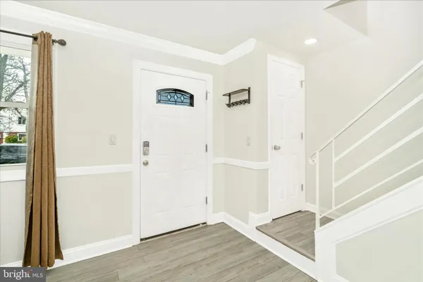 a view of a hallway with wooden floor and entryway