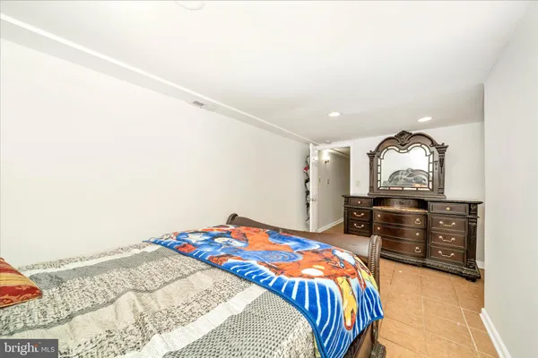 a bedroom with a bed and dresser with mirror