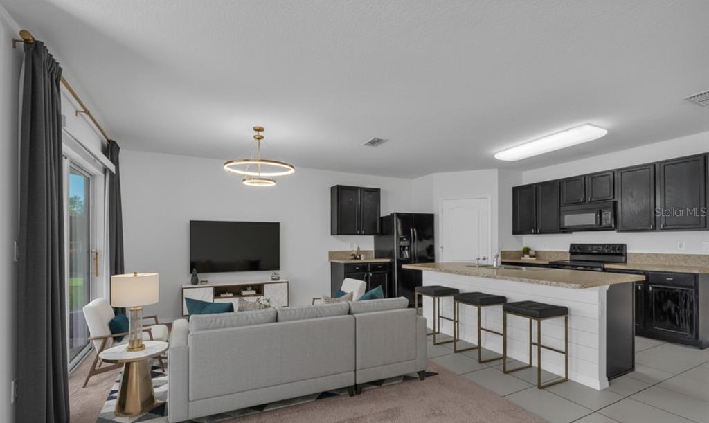 1828 Partin Terrace Road Kissimmee, FL 34744 - Photo 13 of 47 a living room with furniture a flat screen tv and kitchen view