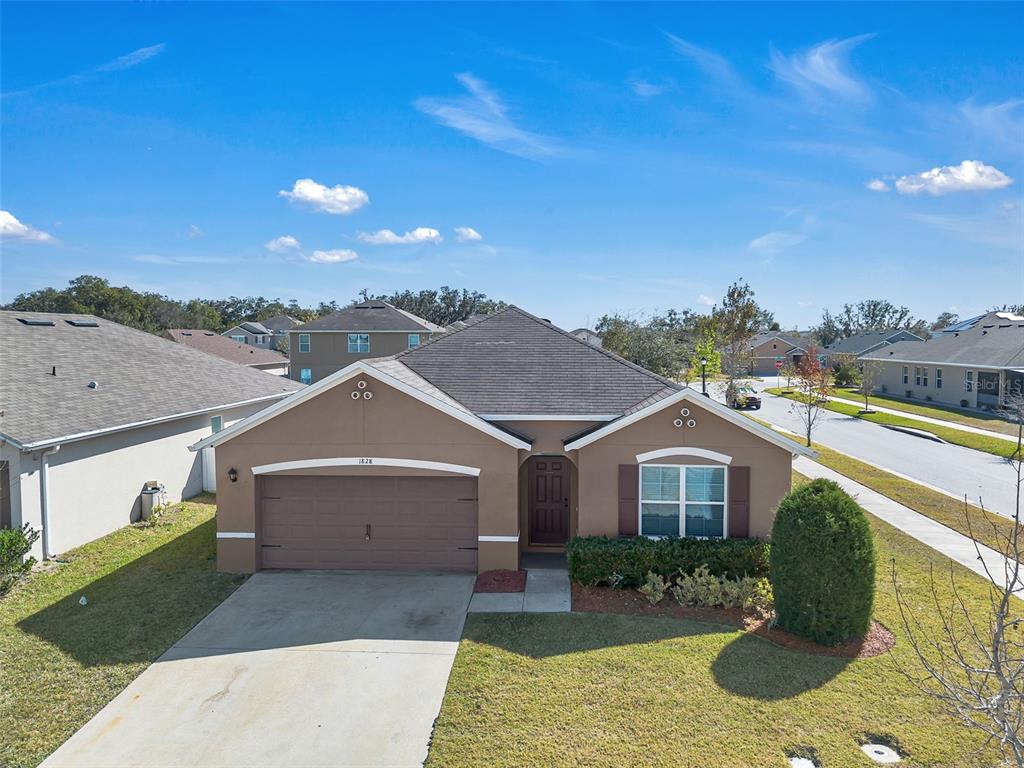 1828 Partin Terrace Road Kissimmee, FL 34744 - Photo 2 of 47 a front view of a house with a yard and garage