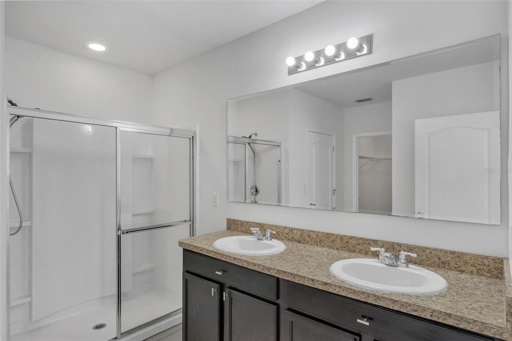 1828 Partin Terrace Road Kissimmee, FL 34744 - Photo 24 of 47 a bathroom with a granite countertop sink a mirror and a shower