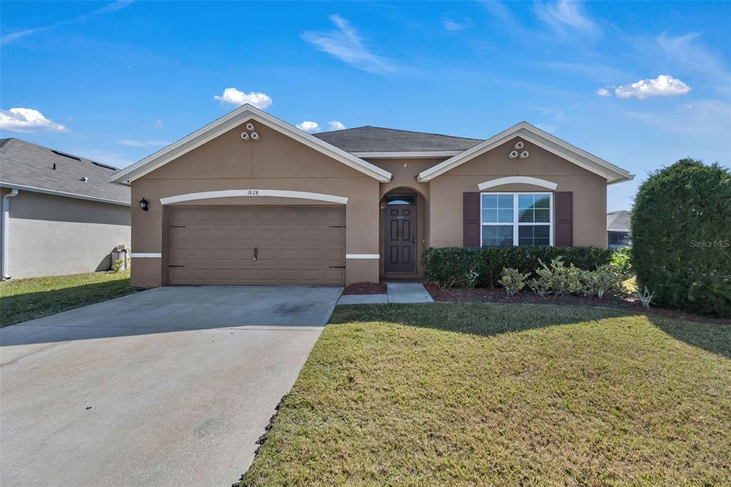 1828 Partin Terrace Road Kissimmee, FL 34744 - Photo 29 of 47 a front view of a house with a yard and garage